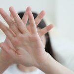 手を顔の前にあてる女性