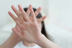 手を顔の前にあてる女性